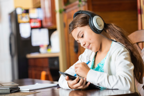 Little girl listening to music with digital tablet device