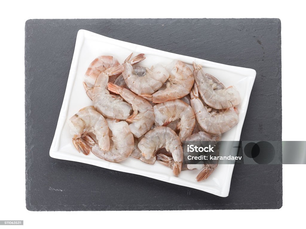 Raw uncooked shrimps Raw uncooked shrimps plate over stone board. Isolated on white background Appetizer Stock Photo