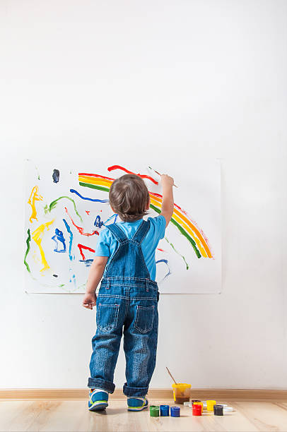 child draws ink on paper child draws colored paint spots on paper child paintbrush stock pictures, royalty-free photos & images