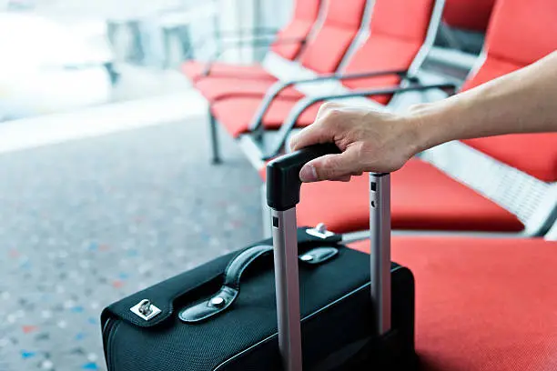 man hand with suitcase at airport.