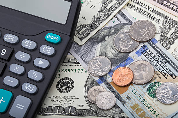 istock USD bank notes with coins and a calculator 511067512