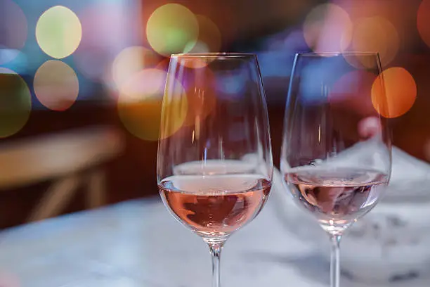 Closeup of pair of wine glasses against de focused background