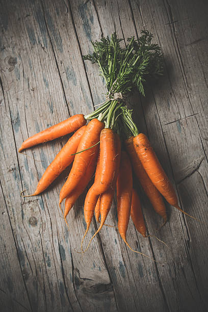 istock Carrot bunch on wooden background 511070042