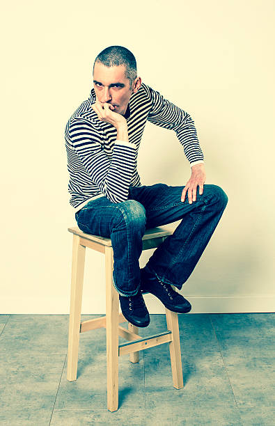 istock depressed 30s man sitting on stool expressing frustration and boredom 511072198