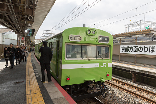 Kyoto, Japan - February 14, 2016 : Passengers at the Tofukuji Station platform. Nara Line Train at the Tofukuji Station in Kyoto, Japan. It is operated by the JR West.