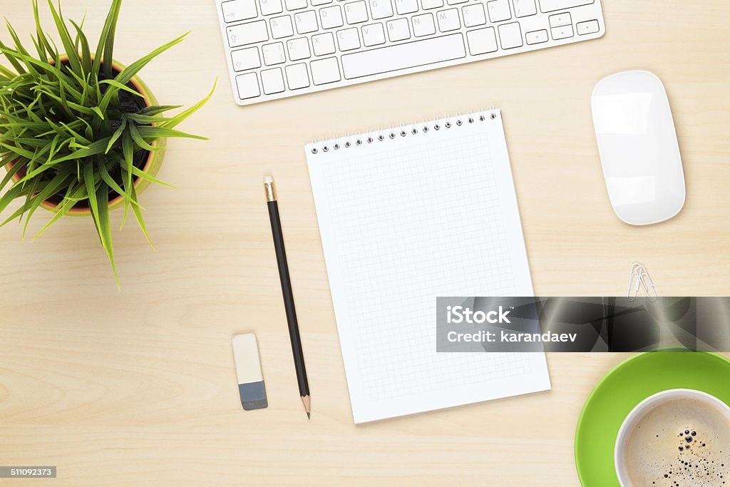 Office table with notepad, computer, coffee cup and flower Office table with notepad, computer, coffee cup and flower. View from above with copy space Above Stock Photo