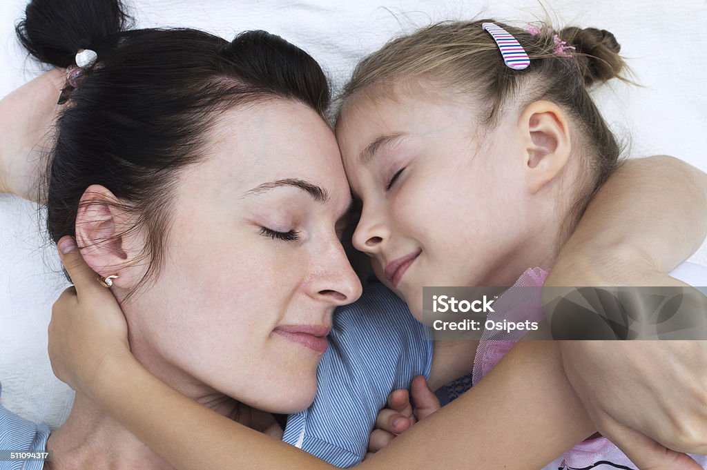 mother and daughter lying on a blanket and hugging each other mother and daughter sleeping and hugging each other. 30-34 Years Stock Photo