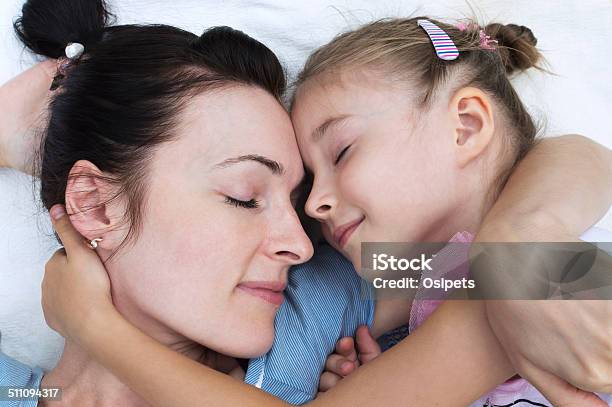 Mother And Daughter Lying On A Blanket And Hugging Each Other Stock Photo - Download Image Now