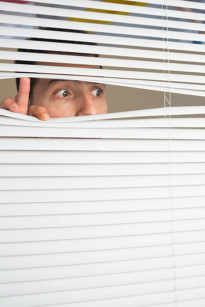 istock Male eyes spying through roller blind 511095163