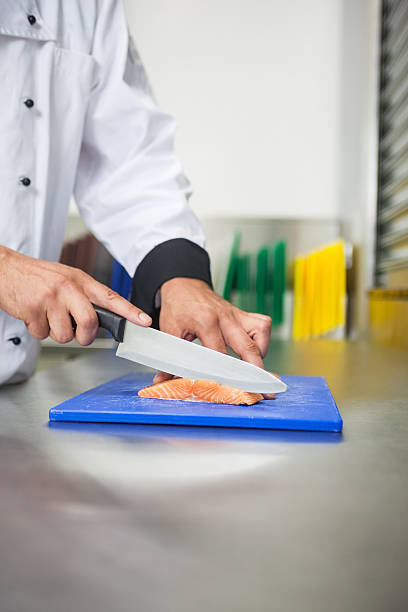 istock Chef slicing raw salmon with knife 511095467