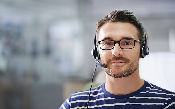 He's here to help! Portrait of a handsome young businessman wearing a headset in the office headset stock pictures, royalty-free photos & images