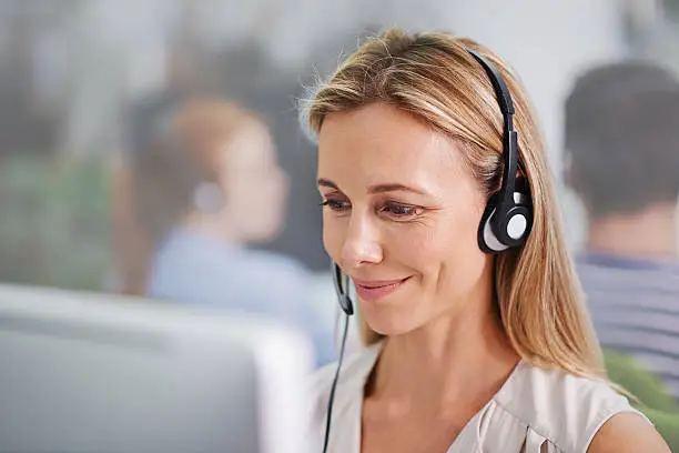 Cropped portrait of an attractive blonde female wearing headsets at work