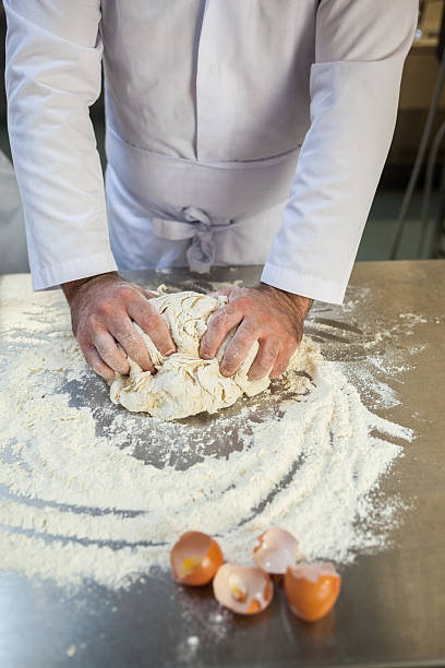 istock Close up of baker kneading dough 511096975