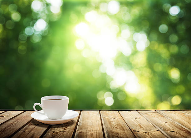 istock cup coffee and sunny trees background 511097429