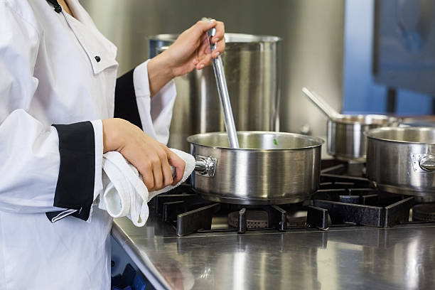 istock Young chef stirring with ladle holding pot 511097553