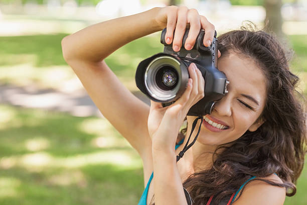 istock Cute brunette woman taking a picture with her camera 511098157