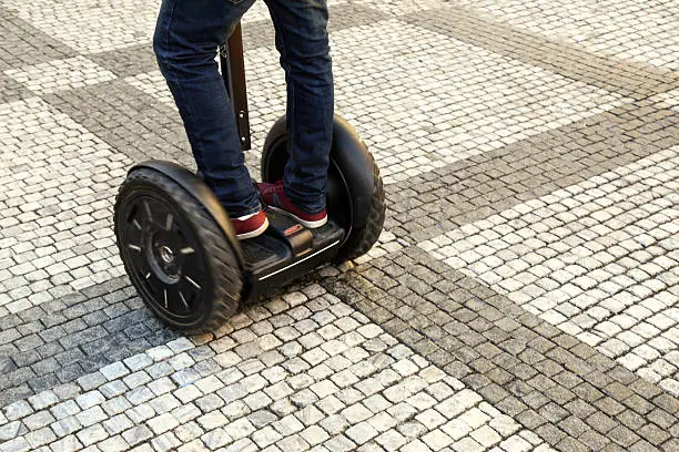 Low angle view of a unrecognizable man driving a segway in town.