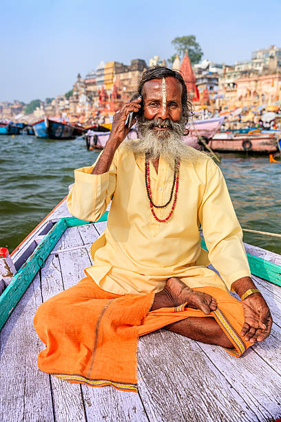 istock Sadhu using mobile in boat on Holy Ganges River, Varanasi 511102678