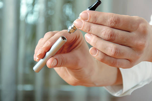 istock Female hand detaches part of the electronic cigarette 511103626