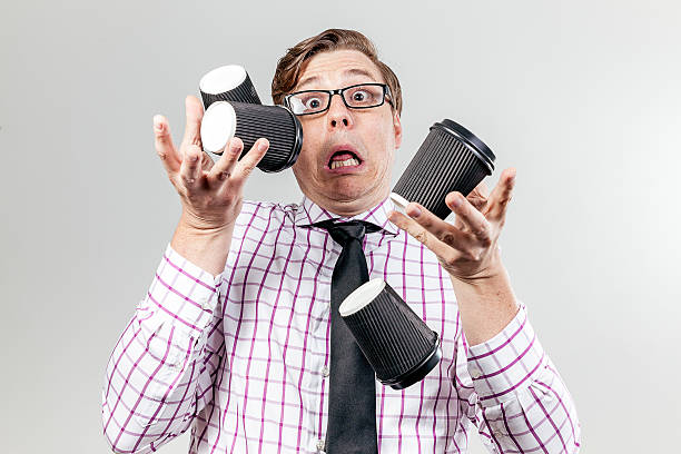 Geek spilling coffee cups everywhere stock photo