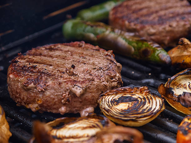 Grilling homemade hamburgers on a grill BBQ stock photo