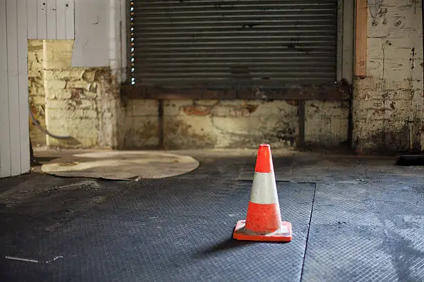 View of safety cone on the floor of an industrial workspace