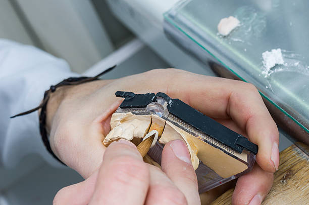 istock Dental technician applying ceramics to teeth in the dental model 511112218