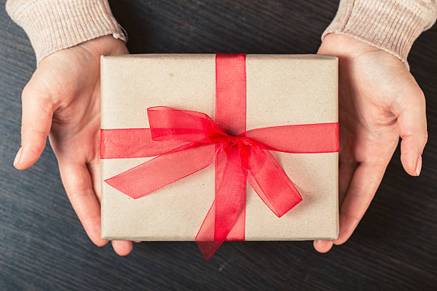 istock girl holding a gift box. Manicure gel nail 511114770