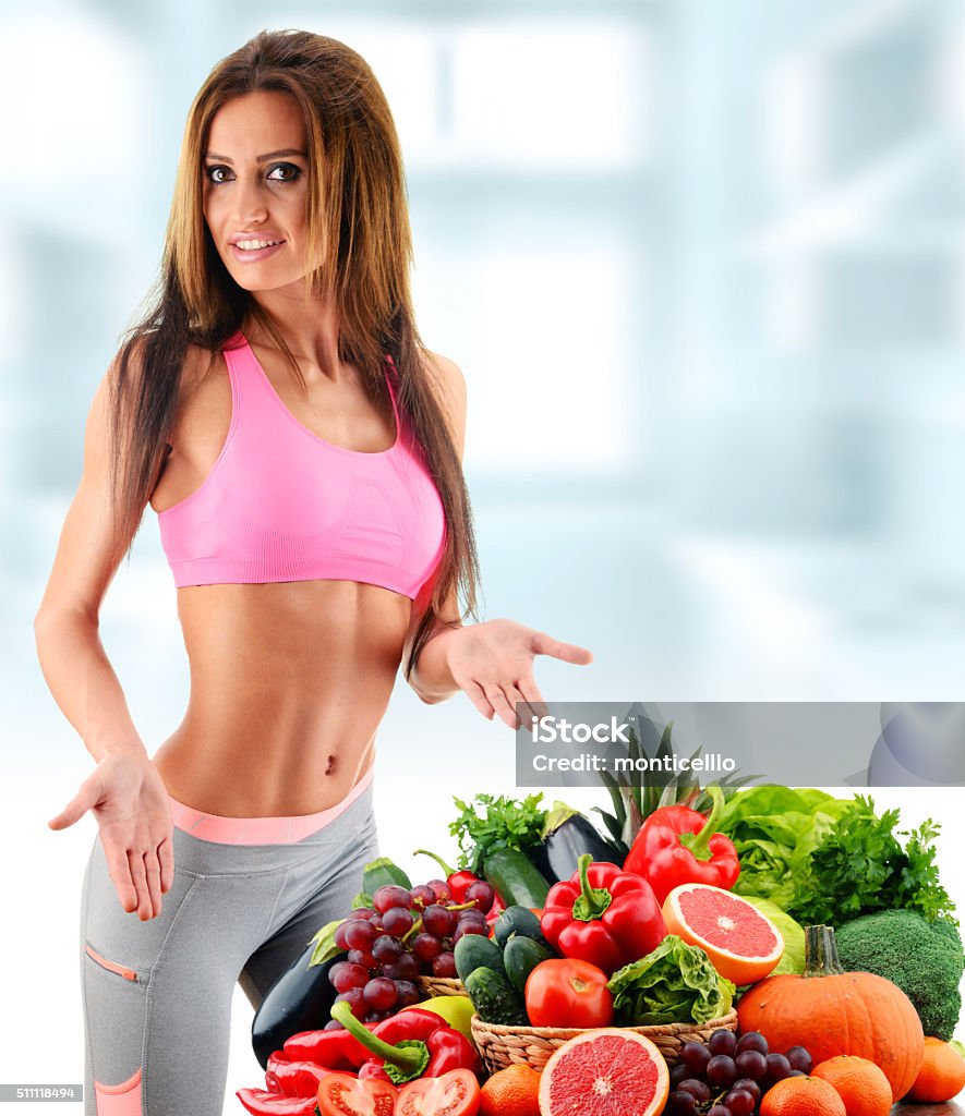 Young woman with variety of organic vegetables and fruits Young woman with variety of organic vegetables and fruits. Buttocks Stock Photo