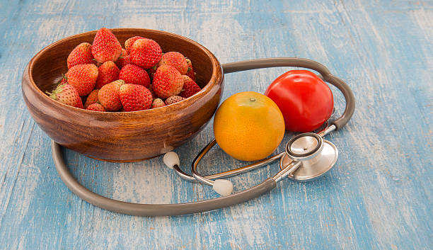 istock Stethoscope,Strawberry.Orange,Tomato on Blue wooden floor. 511119174