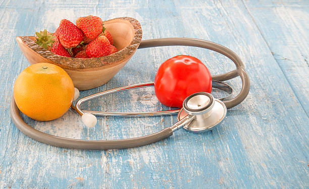 istock Stethoscope,Strawberry.Orange,Tomato on Blue wooden floor. 511119330