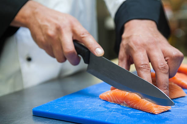 istock Close up of chef slicing salmon with sharp knife 511132475