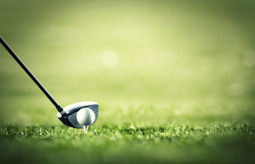 A golf club ready to tee-off with a white ball on a golf course
