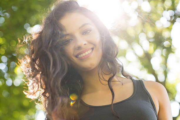 istock Casual smiling brunette standing on grass in sunlight 511139105