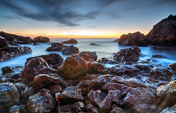 istock Sunrise over the sea and rocky shore 511190548