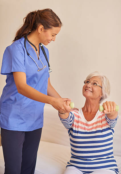 istock Senior female patient with nurse doing gym exercise 511190980
