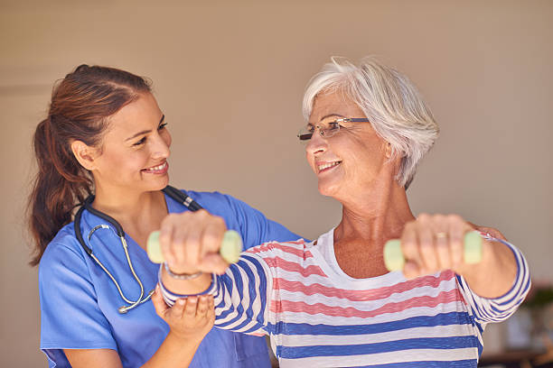 istock Senior female patient with nurse doing gym exercise 511193976