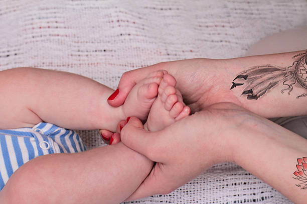 istock Mother holding baby boy's foot 511194438