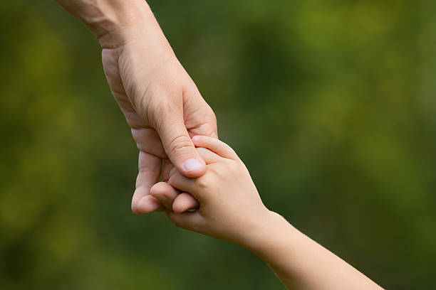 istock mother holding a hand of child 511194650