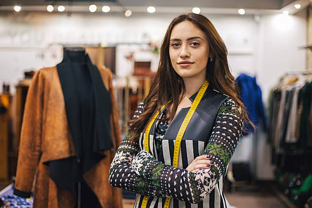 Woman with tape measure in fashion department Portrait of young woman smiling in her fashion store fashion designer stock pictures, royalty-free photos & images