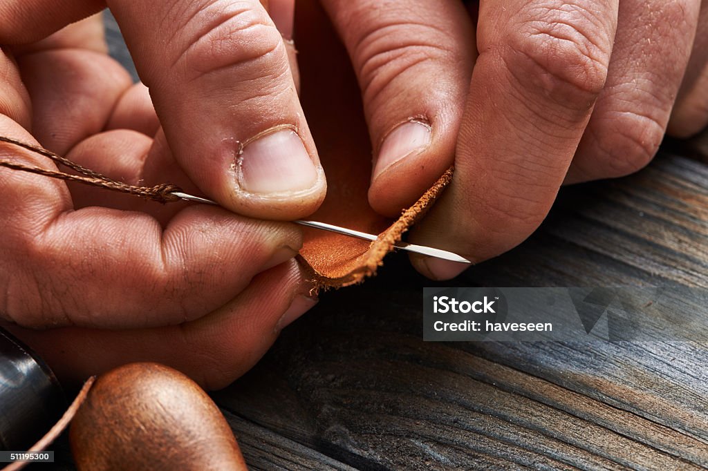 Man working with leather Man working with leather using crafting DIY tools Sewing Stock Photo