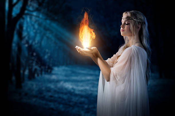Young elven girl holding fire in palms at night forest