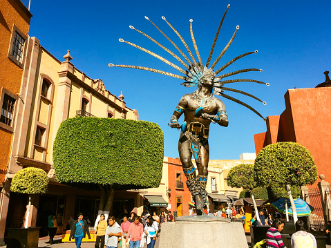 Santiago de Queretaro, Mexico - February 14, 2016: Locals strolling by the Statue of a Dancing Indian, in Spanish called \