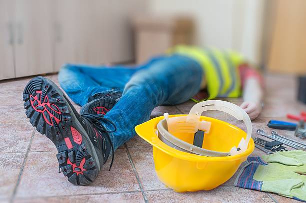istock Leg and yellow helmet of injured lying worker at work. 511199578