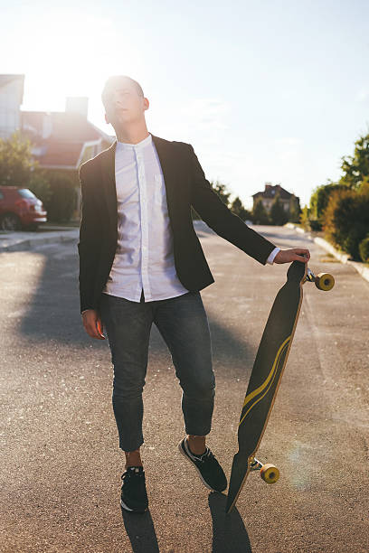 istock Image of a man with longboard going on road 511200130