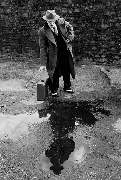 istock black and white image of man in suit and fedora 511208434