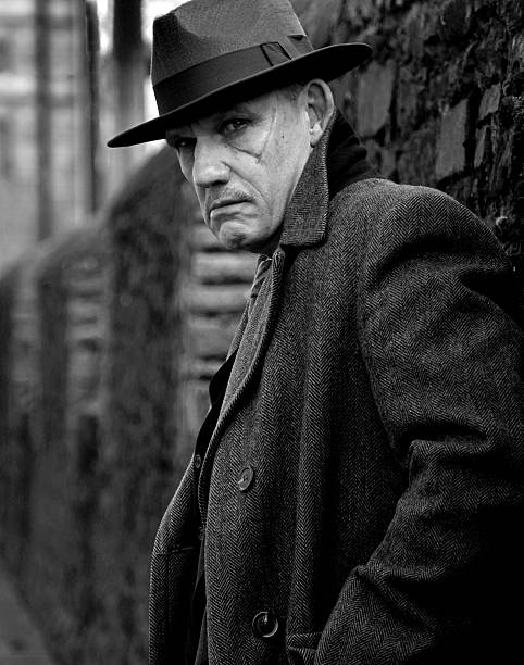 black and white portrait of gangster black and white portrait of gangster leaning against brick wall, he has a menacing expression murderer photos stock pictures, royalty-free photos & images