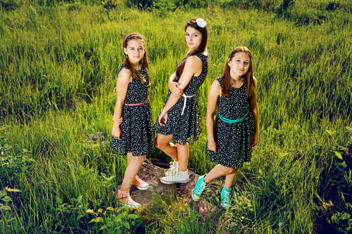 Three sisters are staying in the grass