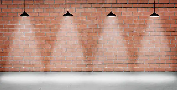 Photo of Brown brick wall lightened with four lamps