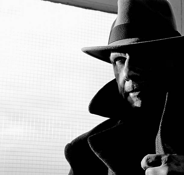 black and white ,film noir style portrait of  gangster or detective in fedora hat